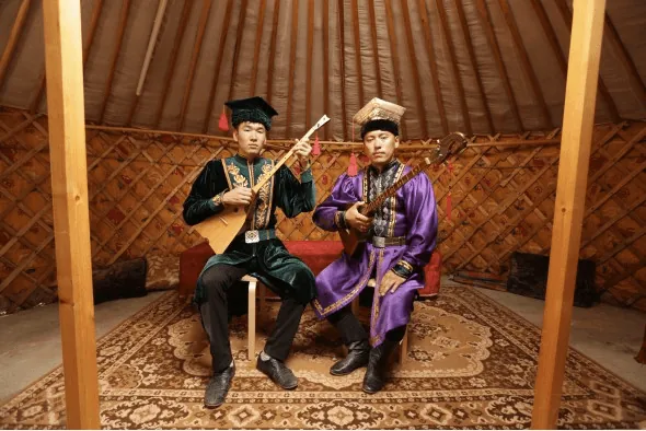 Viktor Olchayev and Dmitri Shanayev play the dombura in traditional Kalmyk dress